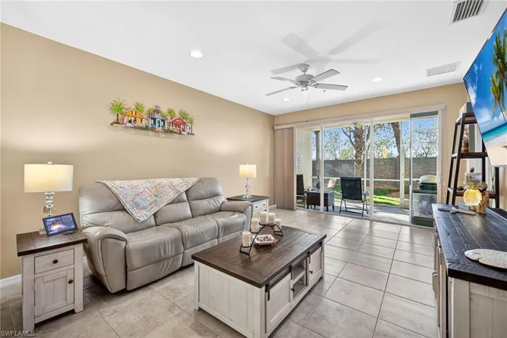 Living room with a ceiling fan, recessed lighting, and light tile patterned flooring