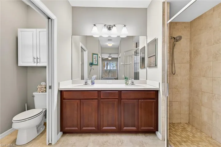 Bathroom featuring a stall shower and double vanity