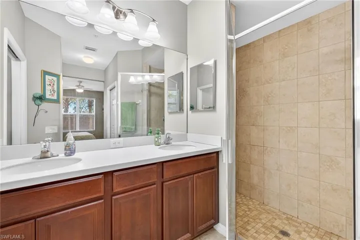 Full bath with ensuite bath, a stall shower, double vanity, and ceiling fan