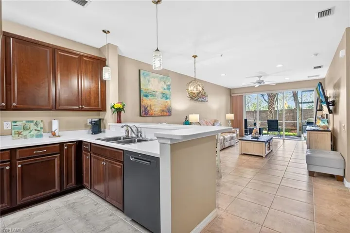 Kitchen featuring hanging light fixtures, dishwasher, open floor plan, light tile patterned floors, and recessed lighting