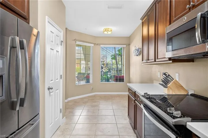 Kitchen featuring appliances with stainless steel finishes, light countertops, and light tile patterned floors