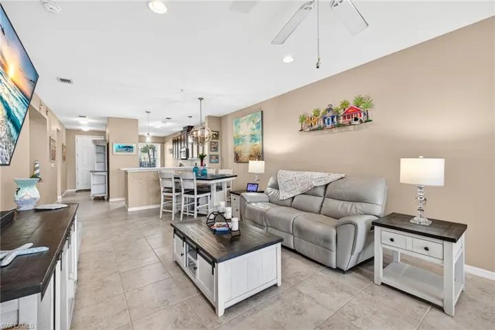 Living room with recessed lighting, ceiling fan, and light tile patterned floors
