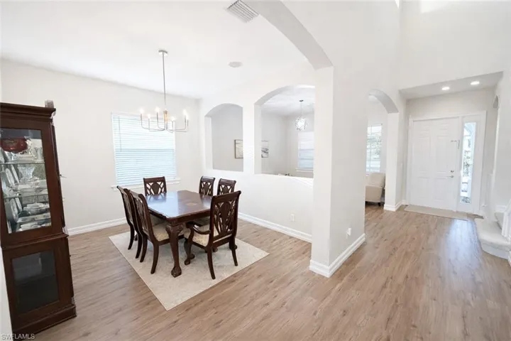 Dining area featuring a chandelier, light wood finished floors, and arched walkways