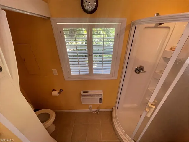Bathroom with a stall shower and tile patterned flooring