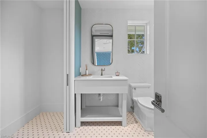 Bathroom with toilet, tile patterned floors, and sink