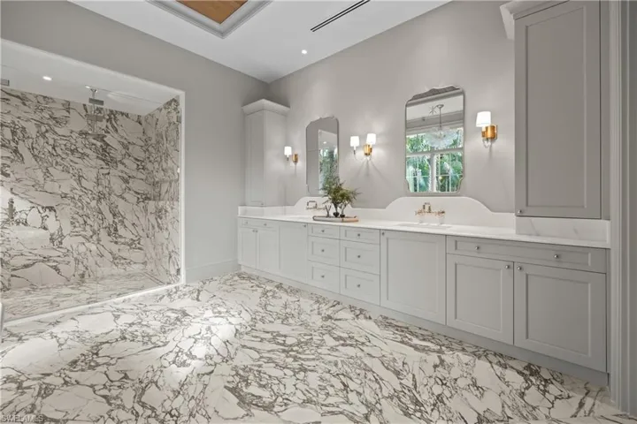 Bathroom featuring a tile shower and vanity