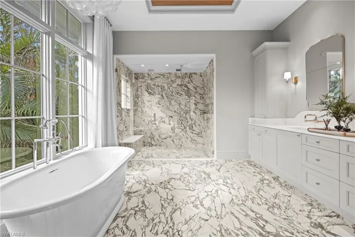 Bathroom featuring separate shower and tub and vanity