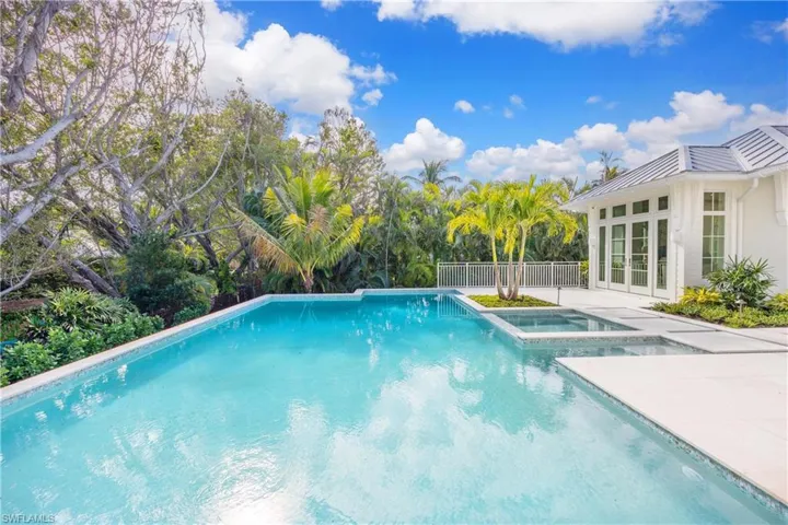 View of pool featuring french doors, a patio area, and an in ground hot tub