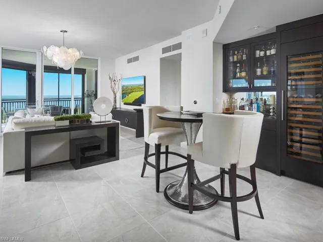 Dining area with bar area, a water view, and a chandelier