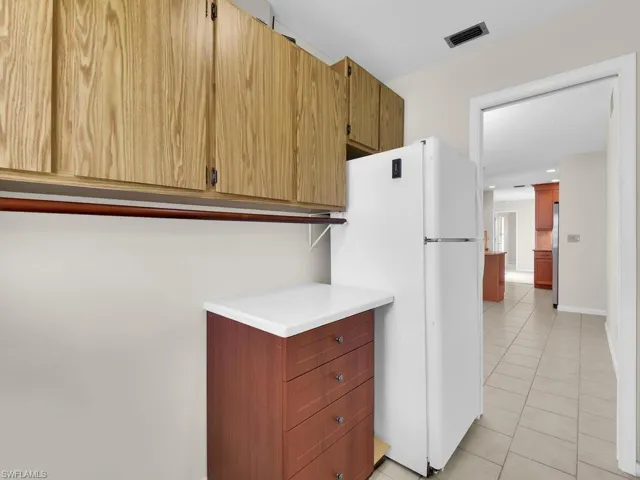 Laundry area with cabinet space, hookup for a washing machine, and light tile patterned floors