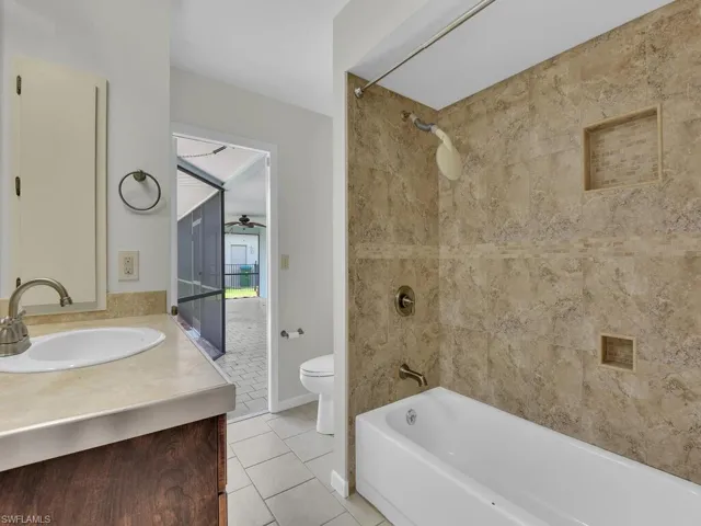 Full bath with vanity, healthy amount of natural light, tiled shower, and a closet