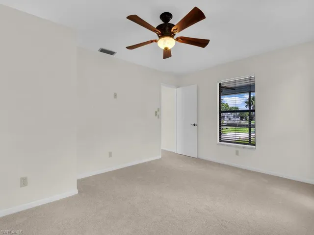 View of dining room area with sliding glass door onto the back patio and the master bedroom door in the background. Taken from the living room