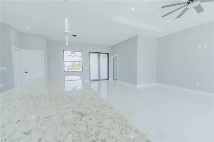 Empty room featuring a tray ceiling, french doors, and ceiling fan