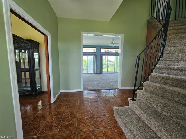 Carpeted foyer entrance with ceiling fan