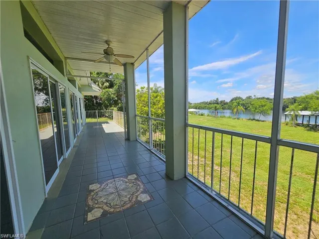 Unfurnished sunroom with ceiling fan, a water view, and a wealth of natural light