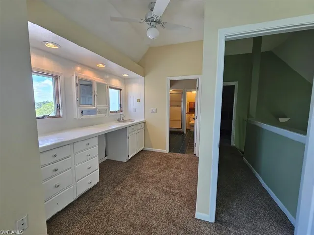Bathroom featuring lofted ceiling, vanity, and ceiling fan