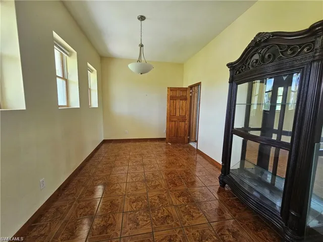 Unfurnished dining area with dark tile patterned floors