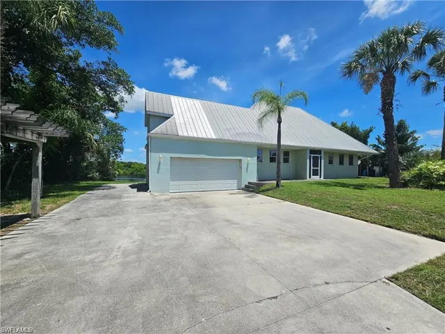 View of front of property with a garage and a front lawn