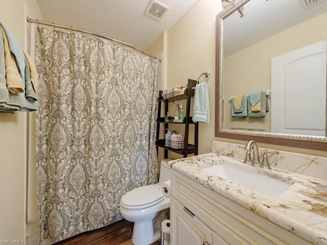 Guest bath just off of the second bedroom features granite counters with inset sink, tile floors and a shower/tub combo.