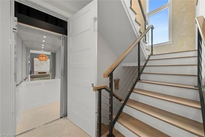 Modern stairway complemented by a private elevator for easy access between levels.