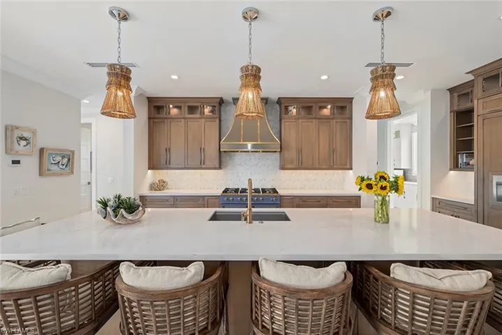 Large kitchen island with seating and statement pendant lighting.