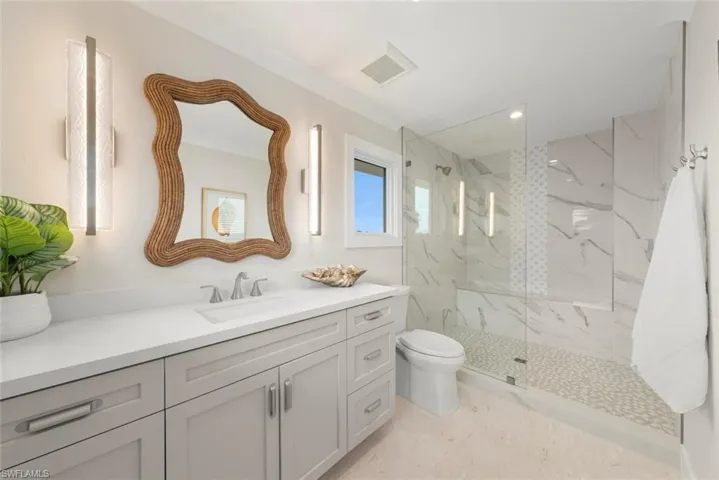 Secondary bathroom with sink, custom cabinetry, a shower and modern finishes.