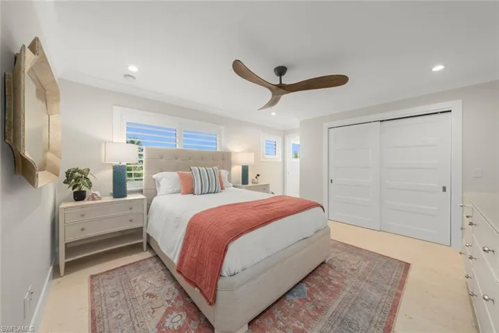 Bedroom 2 with ceiling fan, spacious layout, and abundant natural light.
