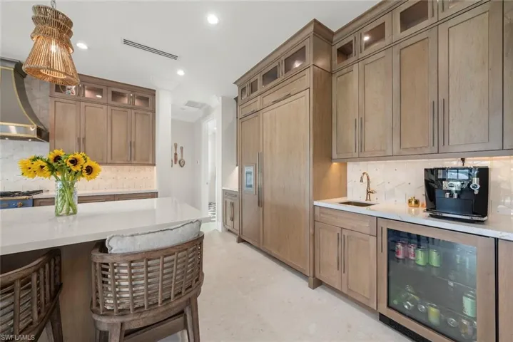 Built-in beverage station featuring a beverage refrigerator, ice maker, and generous cabinetry for storage and prep.