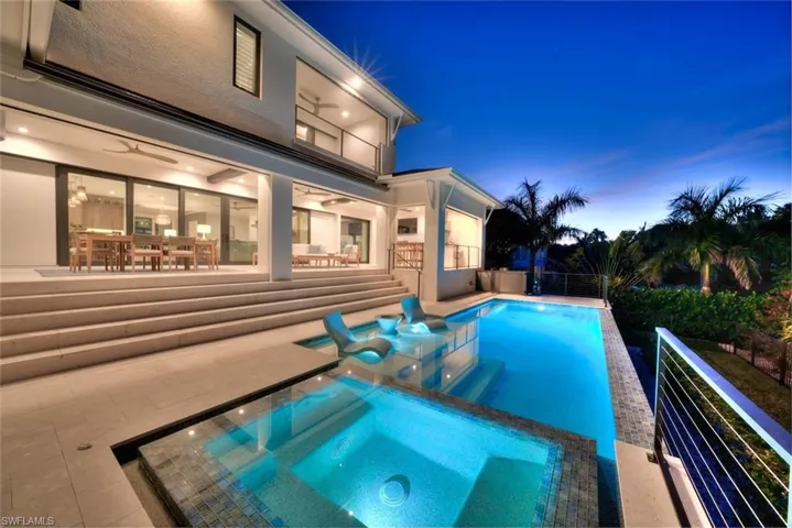 Rear view featuring a resort-style pool, spa, and expansive outdoor living space