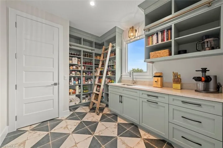 Spacious walk-in pantry with built-in shelving and ladder access offering abundant storage and organization.