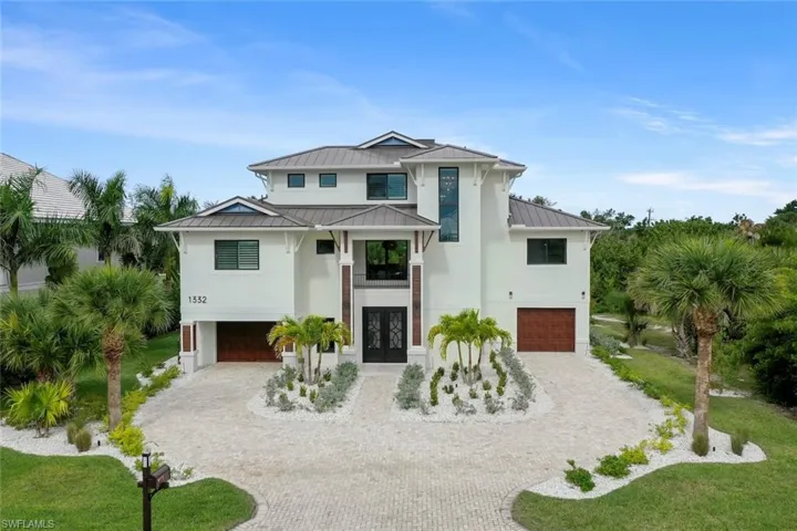 Aerial front view showcasing the home’s elevation and outdoor spaces.