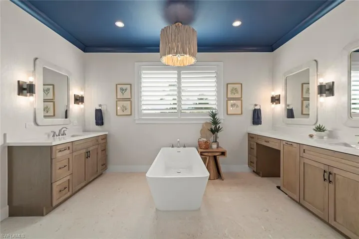 Primary bathroom with dual sinks, center island and a bath tub.