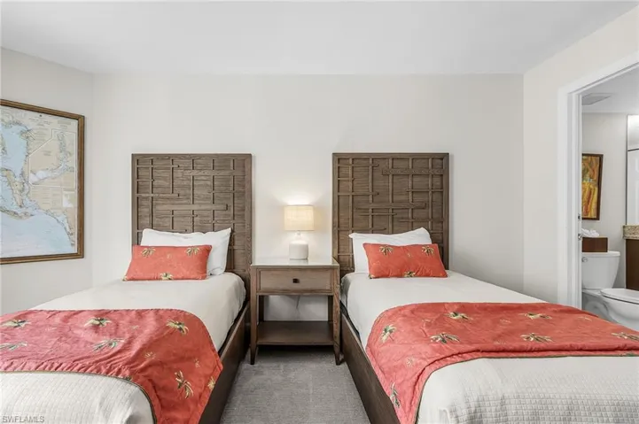 Dual wood-panel headboards, coordinated wood-finish nightstand with single drawer, and soft gray carpeting