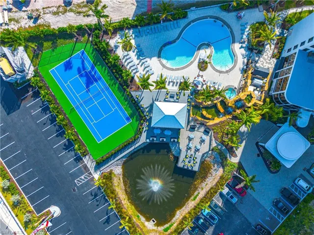 Full-size tennis court, expansive parking areas, large freeform swimming pool, integrated spa, and a serene pond with a fountain