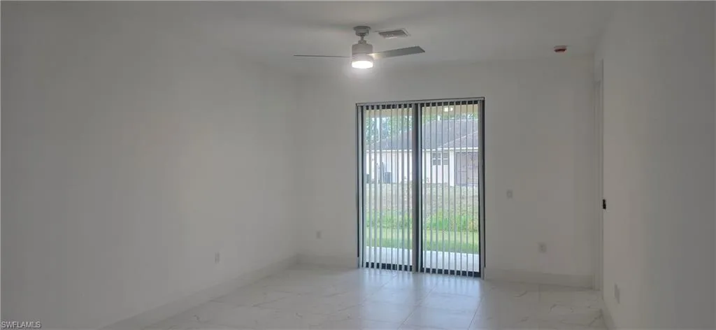 Empty room with light marble finish flooring and ceiling fan