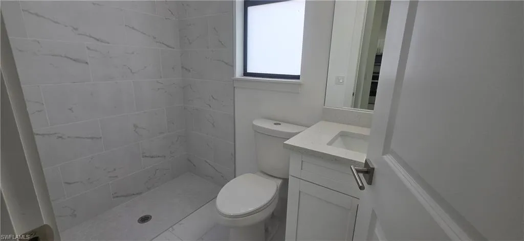 Full bathroom featuring vanity, a shower stall, and light marble finish floors