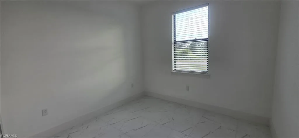 Spare room with light marble finish floors and baseboards