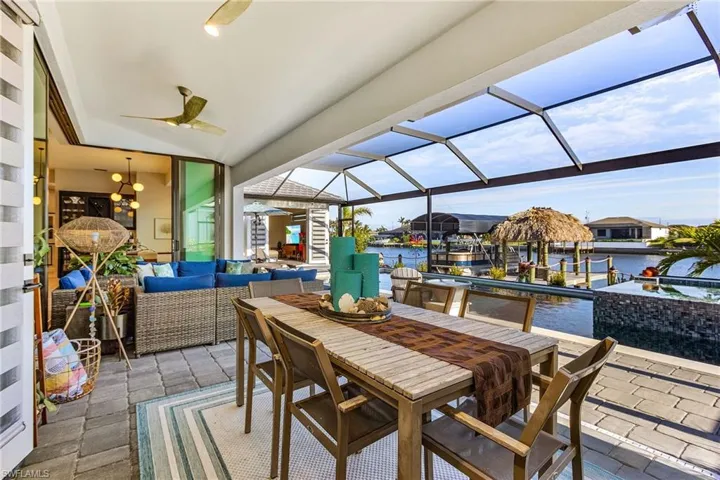 View of patio / terrace with a water view, ceiling fan, an outdoor living space, and glass enclosure