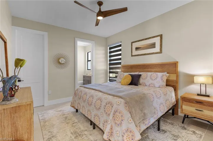Tiled bedroom with ceiling fan and ensuite bathroom