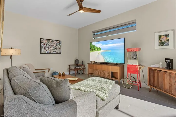 Living room with tile patterned flooring and ceiling fan