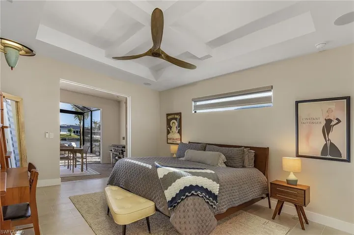 Bedroom with coffered ceiling, access to outside, a raised ceiling, and ceiling fan