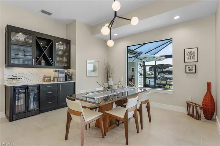 Tiled dining area featuring indoor bar and beverage cooler