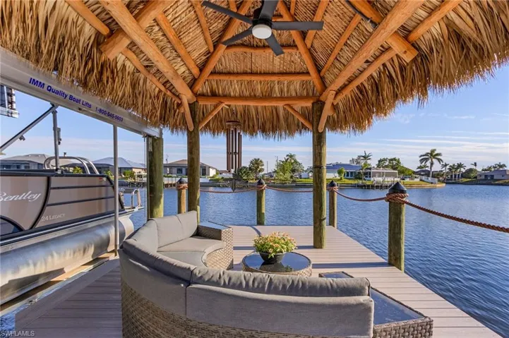 Dock area with an outdoor living space, a gazebo, and a water view