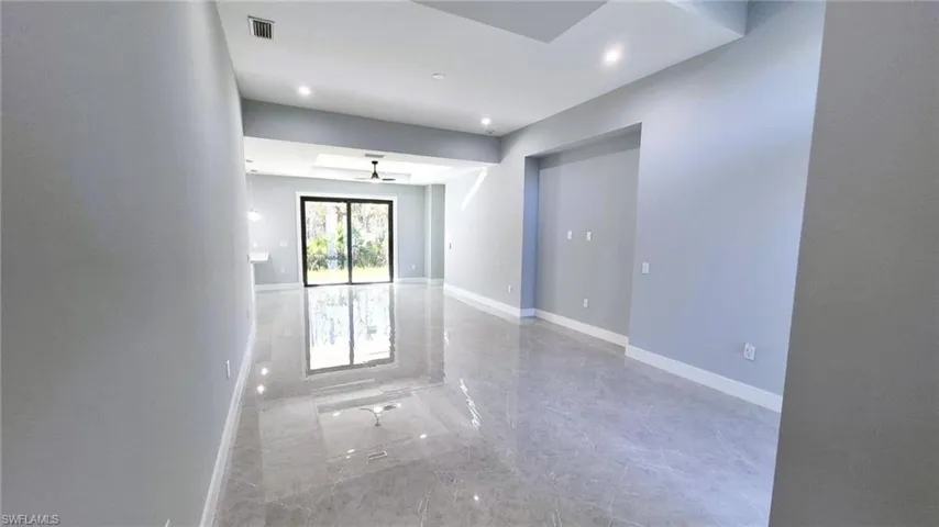 Unfurnished room with light marble finish floors and recessed lighting