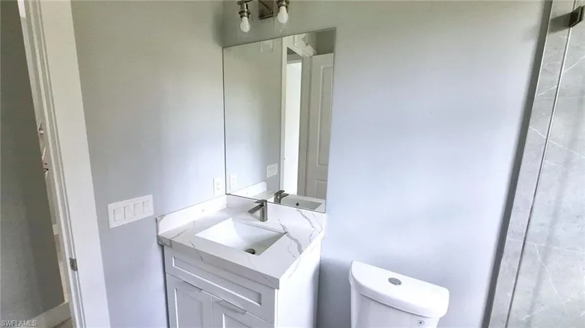 Half bathroom with vanity and toilet
