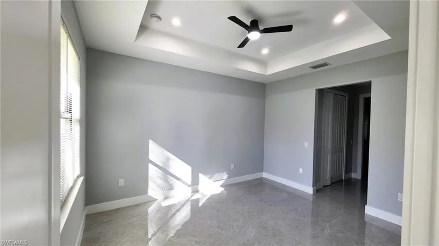 Spare room featuring a tray ceiling, ceiling fan, and recessed lighting