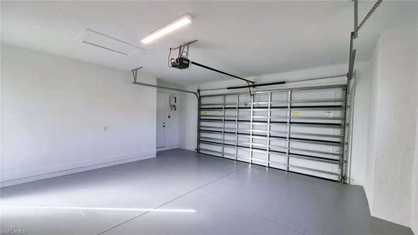 Garage with baseboards and a garage door opener