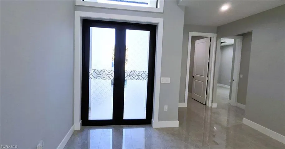 Foyer featuring baseboards and french doors