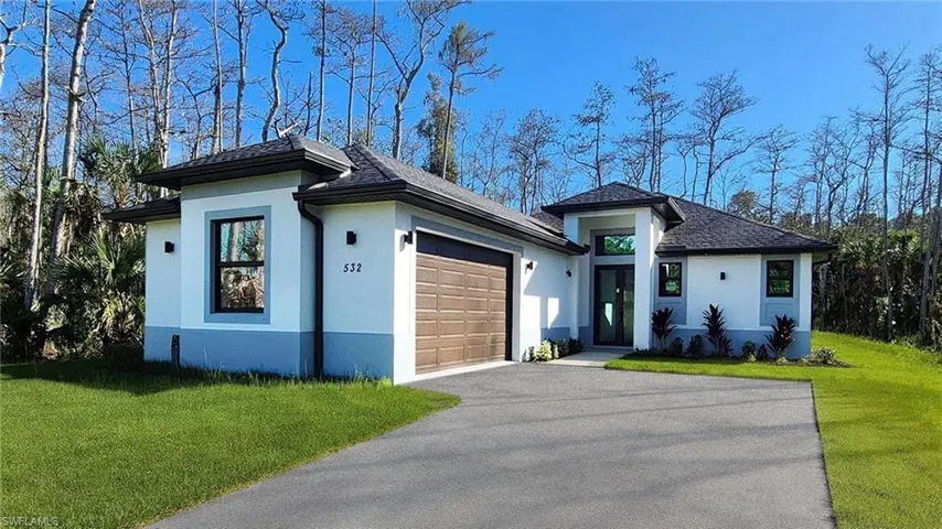 Prairie-style house with a front lawn, stucco siding, and asphalt driveway