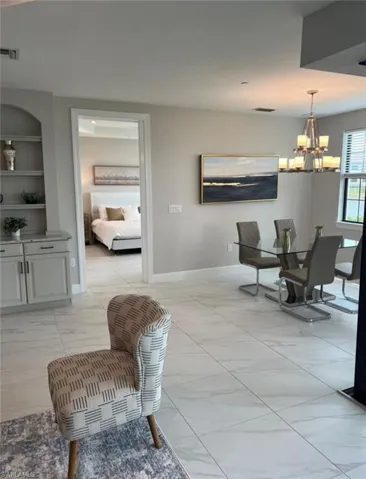 Dining area with light marble finish floors, built in features, and hanging lights